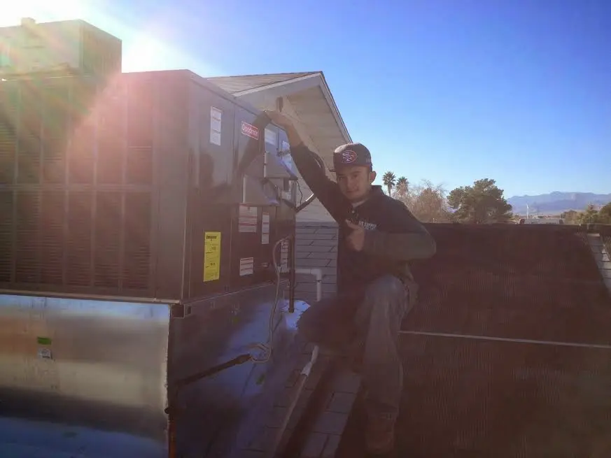 HVAC technician performing HVAC Inspection on a rooftop unit in Orleans